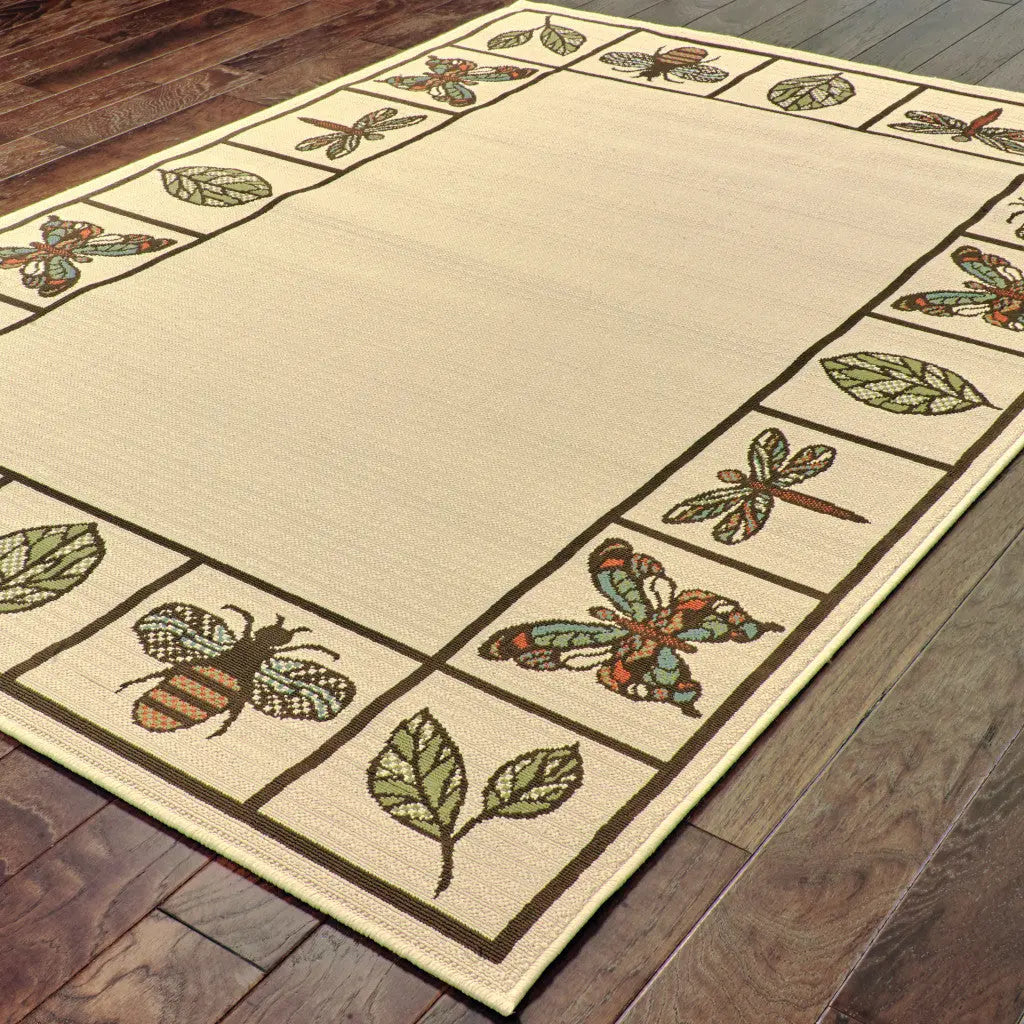 Beige outdoor rug with floral and insect patterns in green and blue, ideal for garden or patio decor.