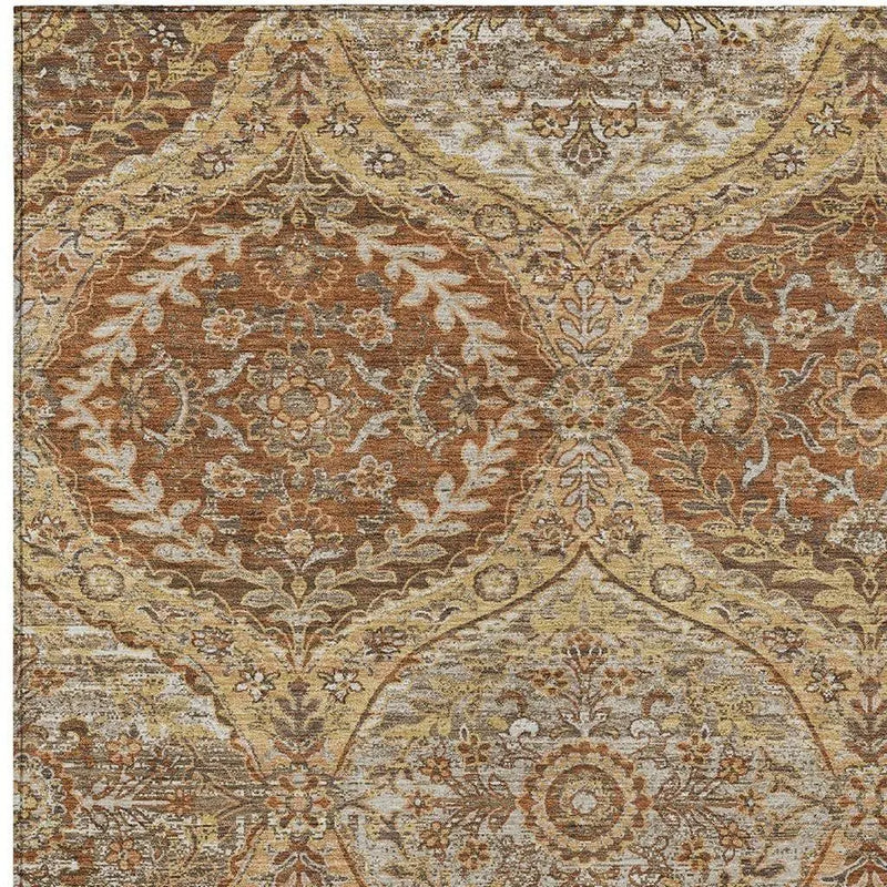 Vintage-inspired area rug in warm gold, orange, and cream, featuring intricate floral motifs and a soft, plush texture.