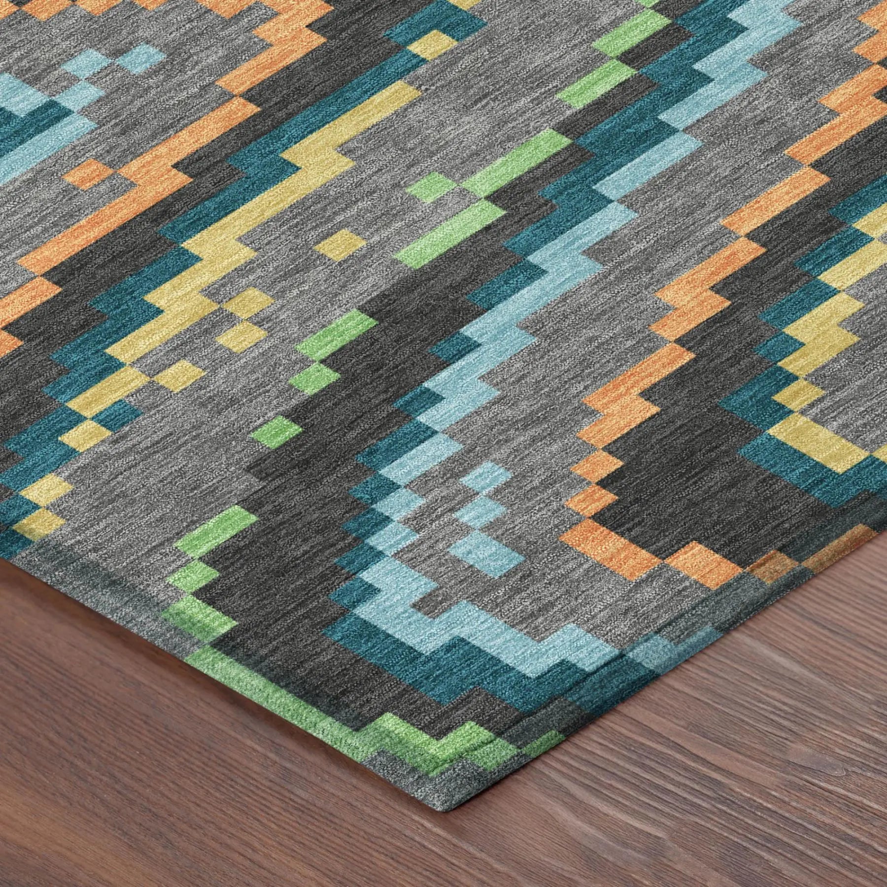 Multicolored geometric area rug in gray, orange, blue, and green, made from durable synthetic fibers.