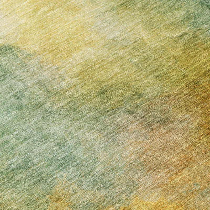 Multicolored abstract area rug in shades of green, gold, and beige, featuring a soft, textured fabric finish.
