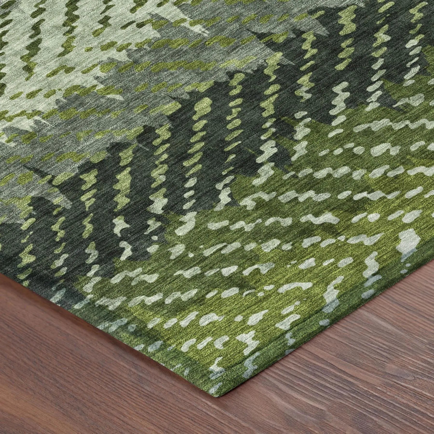 Green abstract area rug in varying shades of olive and sage, crafted from soft synthetic fibers, ideal for modern decor.