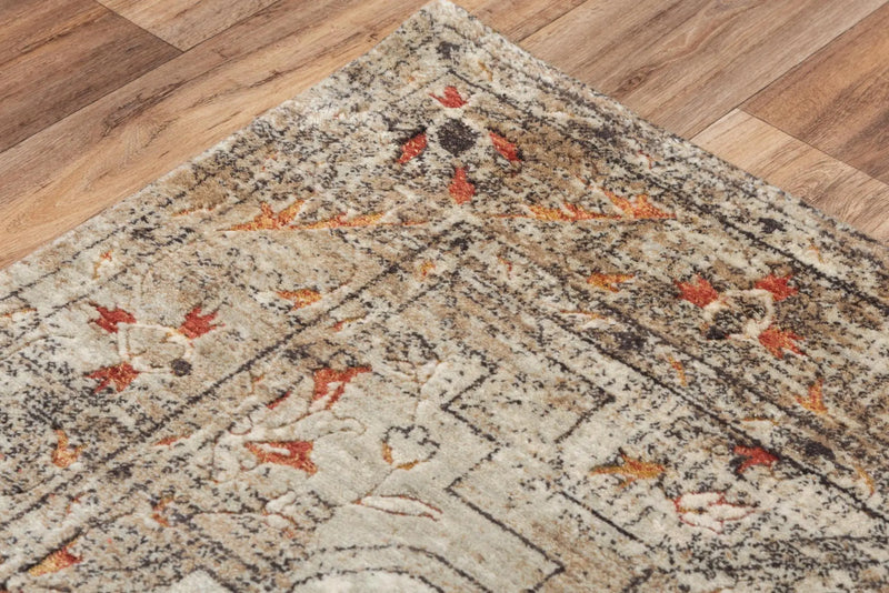 Vintage-style area rug in cream, blue, and orange, featuring intricate floral patterns on a distressed background.