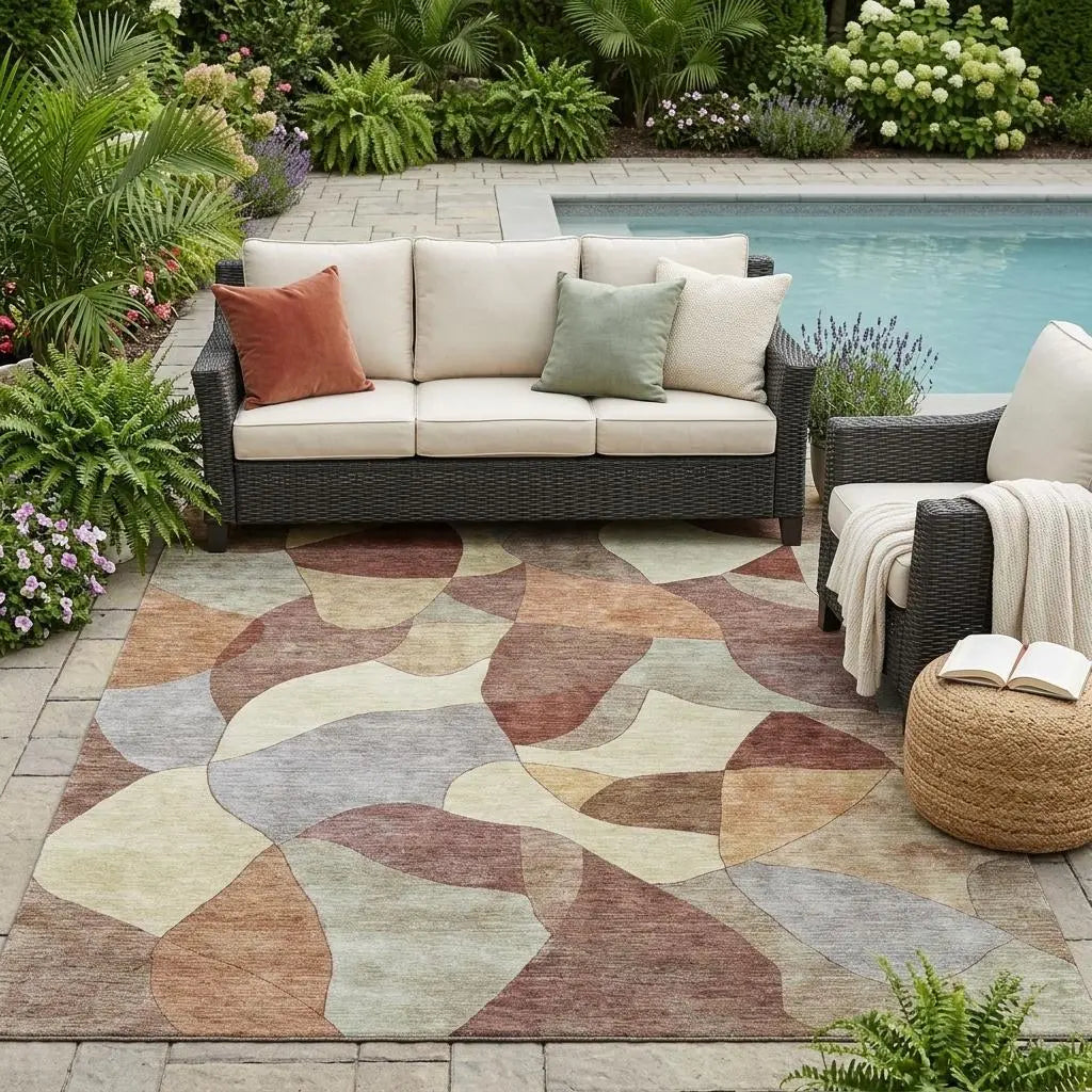 Multicolor geometric outdoor rug in soft beige, brown, and green, complementing a modern patio setting.
