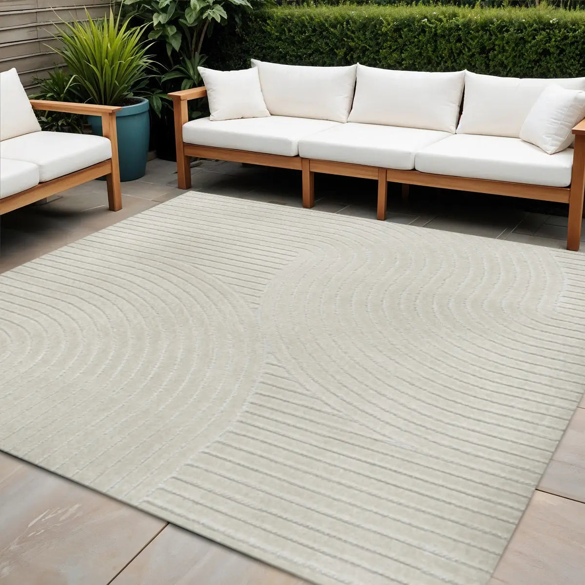 Beige outdoor rug with textured wave pattern, ideal for patio decor, complemented by wooden sofa with white cushions.