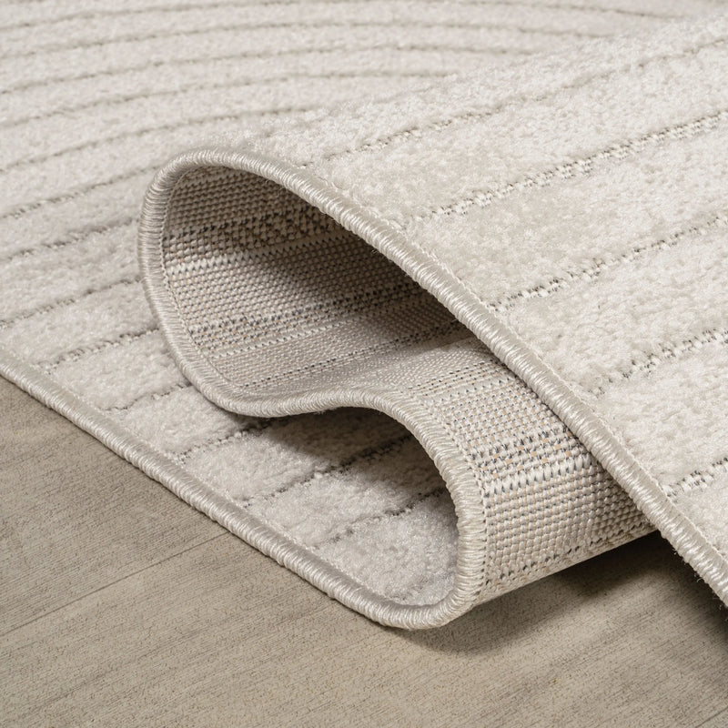Cream textured area rug with beige stripes, soft fabric, and a modern design, perfect for living spaces.