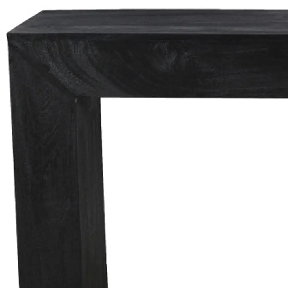 Black wooden table with a minimalist design, featuring a sturdy rectangular frame and a smooth finish.
