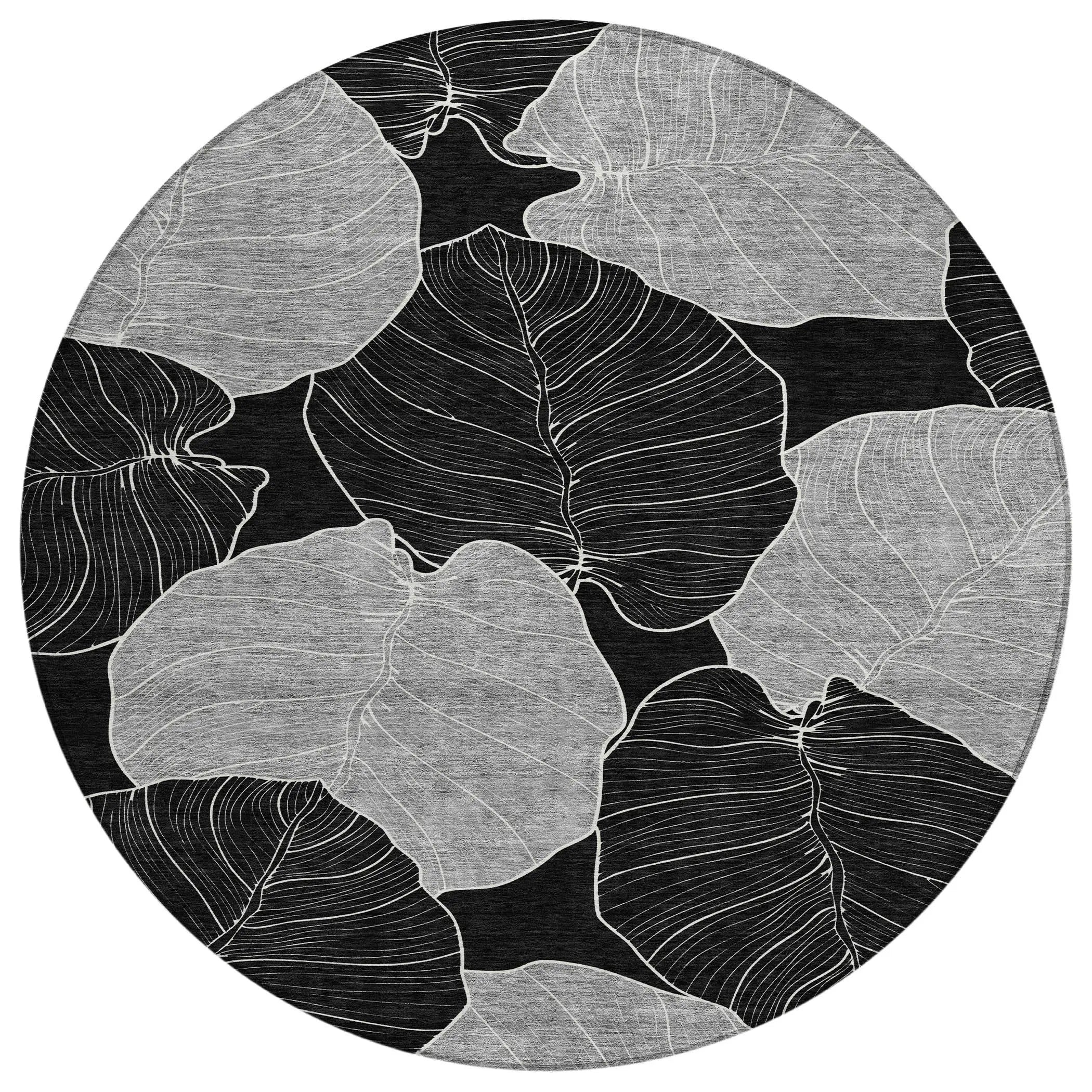 Black and white leaf-patterned round rug, made of durable material, perfect for modern home decor.