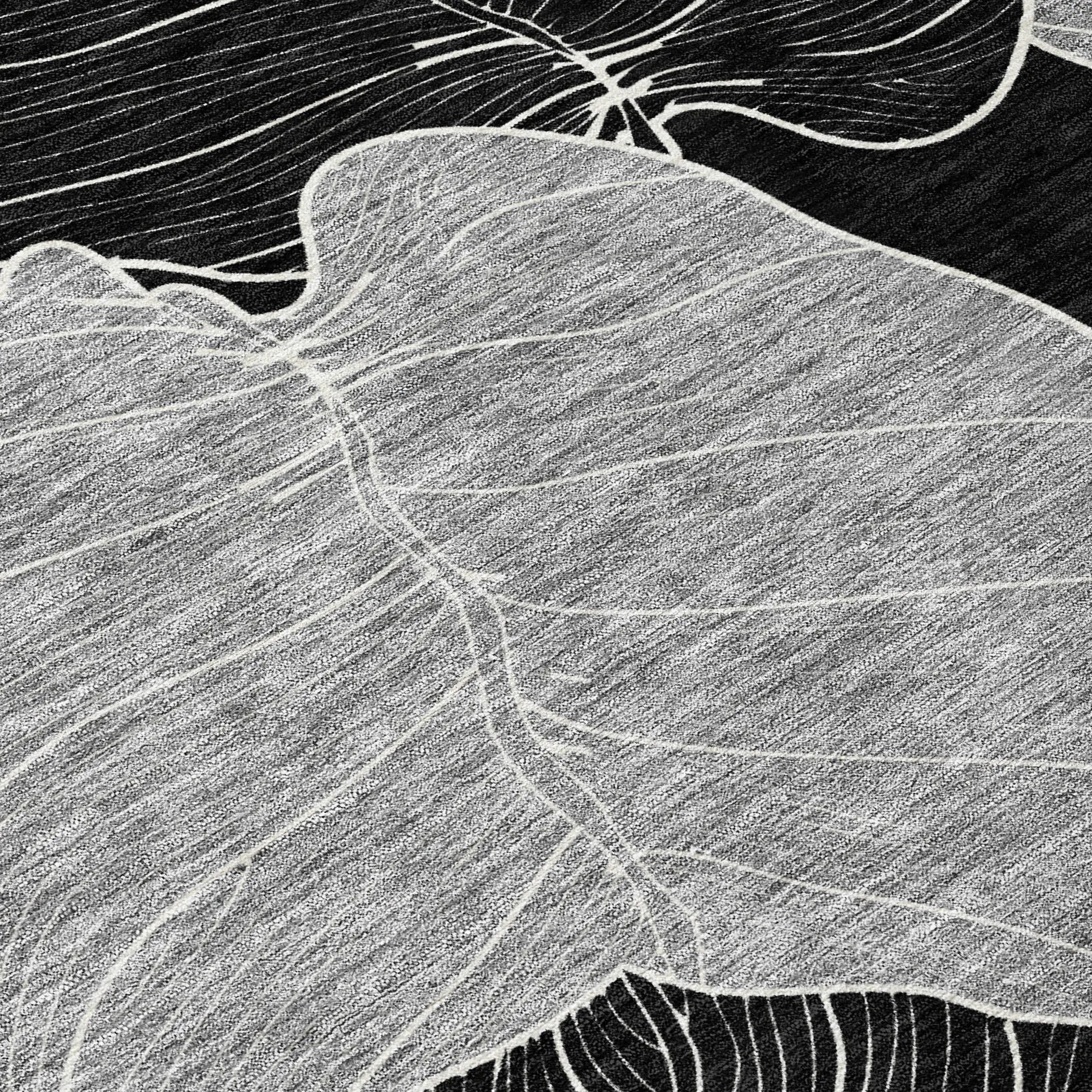 Black and gray abstract area rug with intricate white leaf patterns, modern style for contemporary decor.