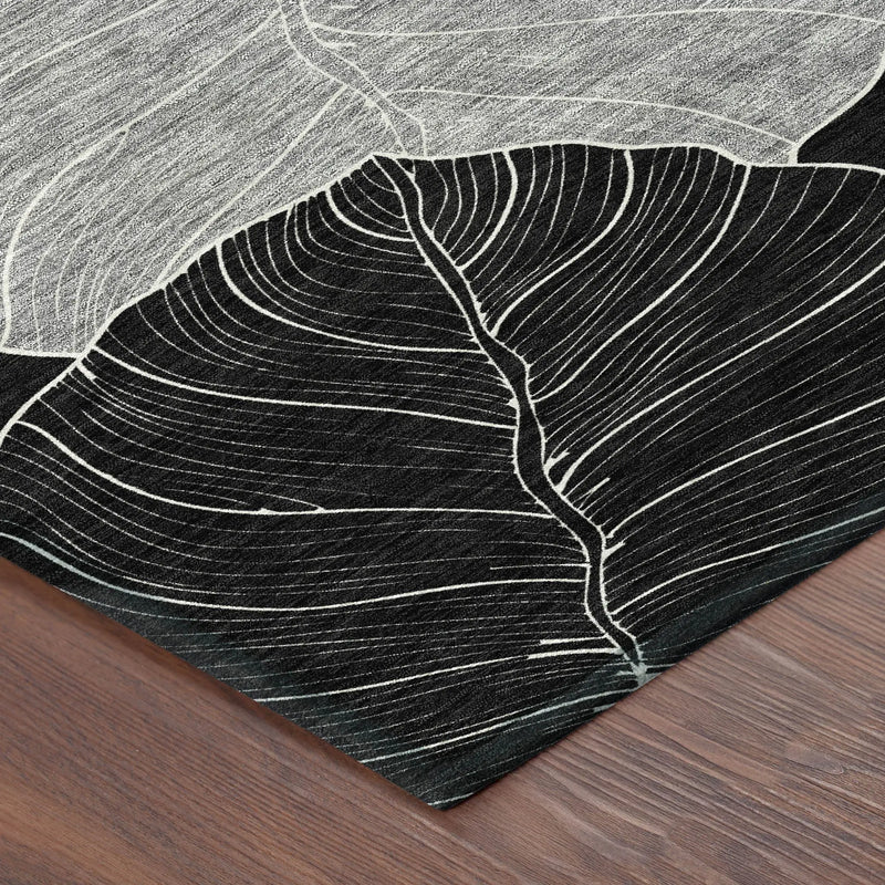 Black and white leaf-patterned area rug, textured fabric, modern style, perfect for contemporary decor.