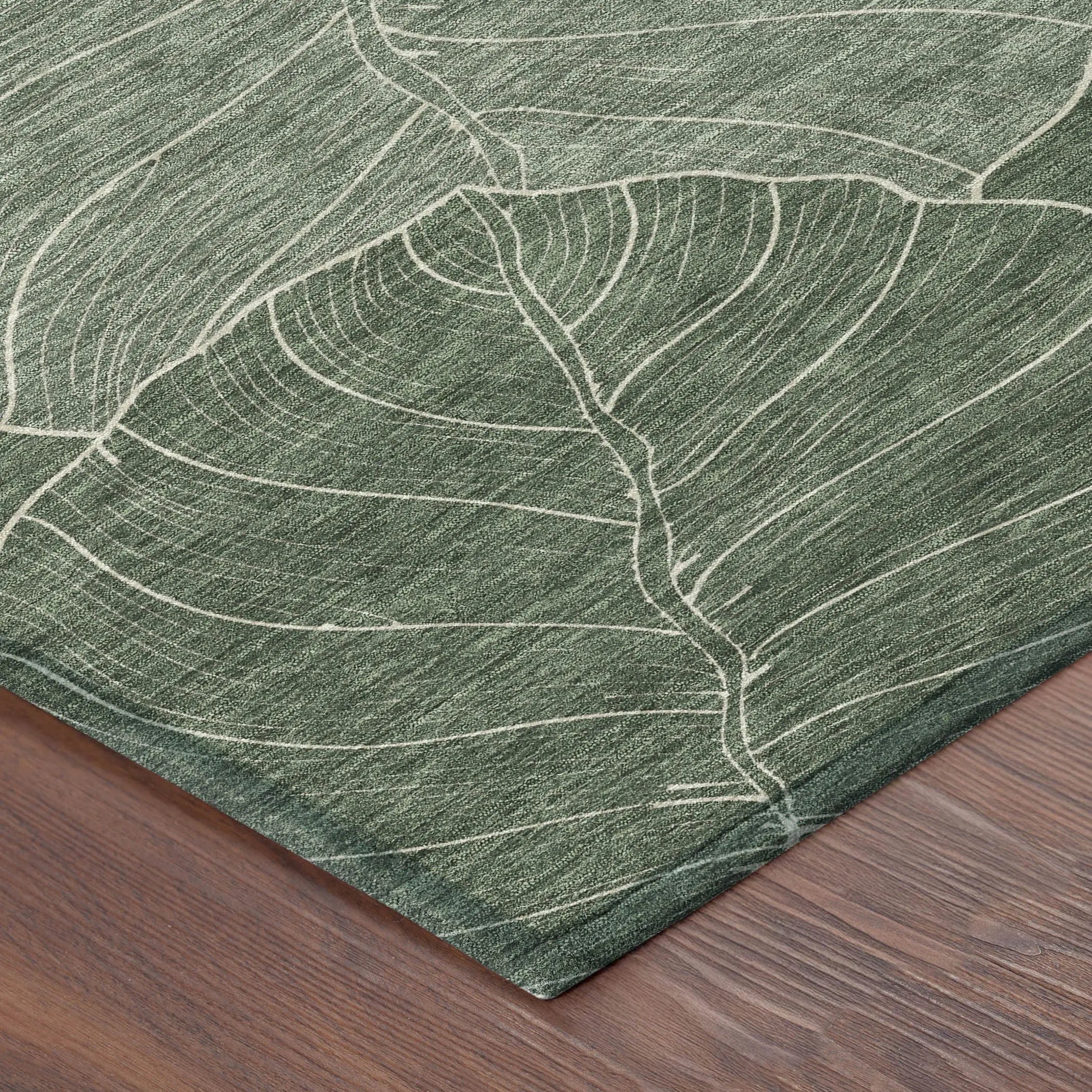Green leaf-patterned area rug, crafted from durable material, featuring a subtle, nature-inspired design on a wood floor.