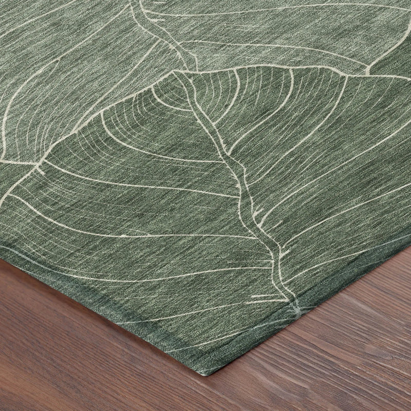 Green leaf-patterned area rug, crafted from durable material, featuring a subtle, nature-inspired design on a wood floor.