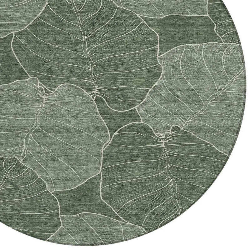 Round green leaf-patterned area rug with intricate white line detailing, made of soft, durable fabric.