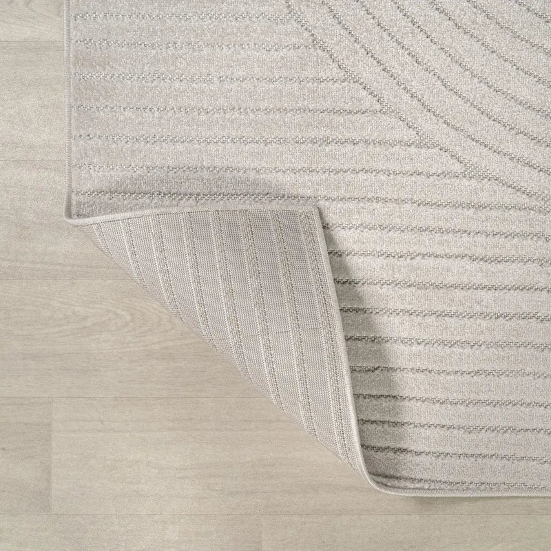 Light beige textured area rug with a subtle striped pattern, featuring a soft, plush pile and durable backing.