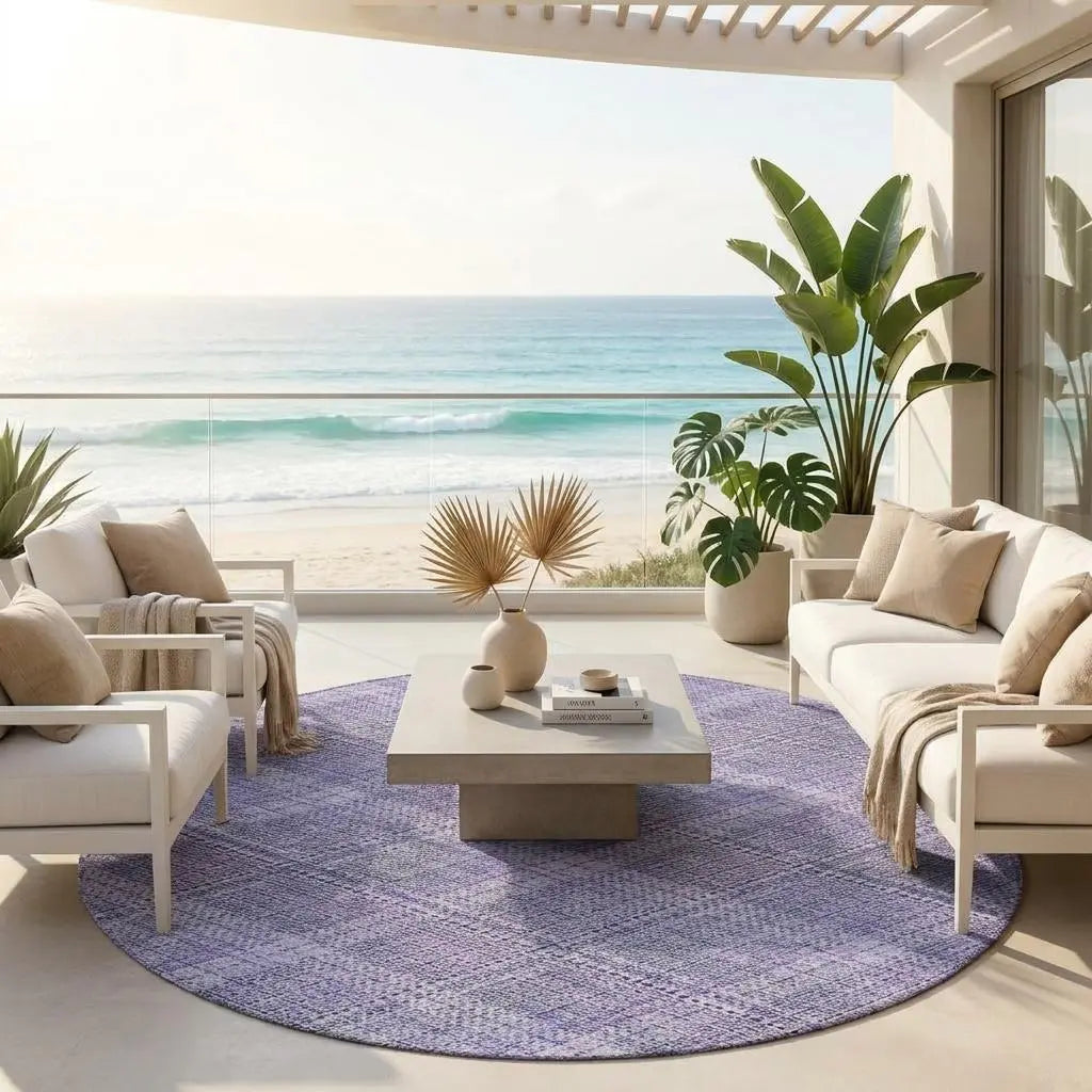 Stylish purple woven area rug in a coastal patio setting with white furniture and tropical plants.