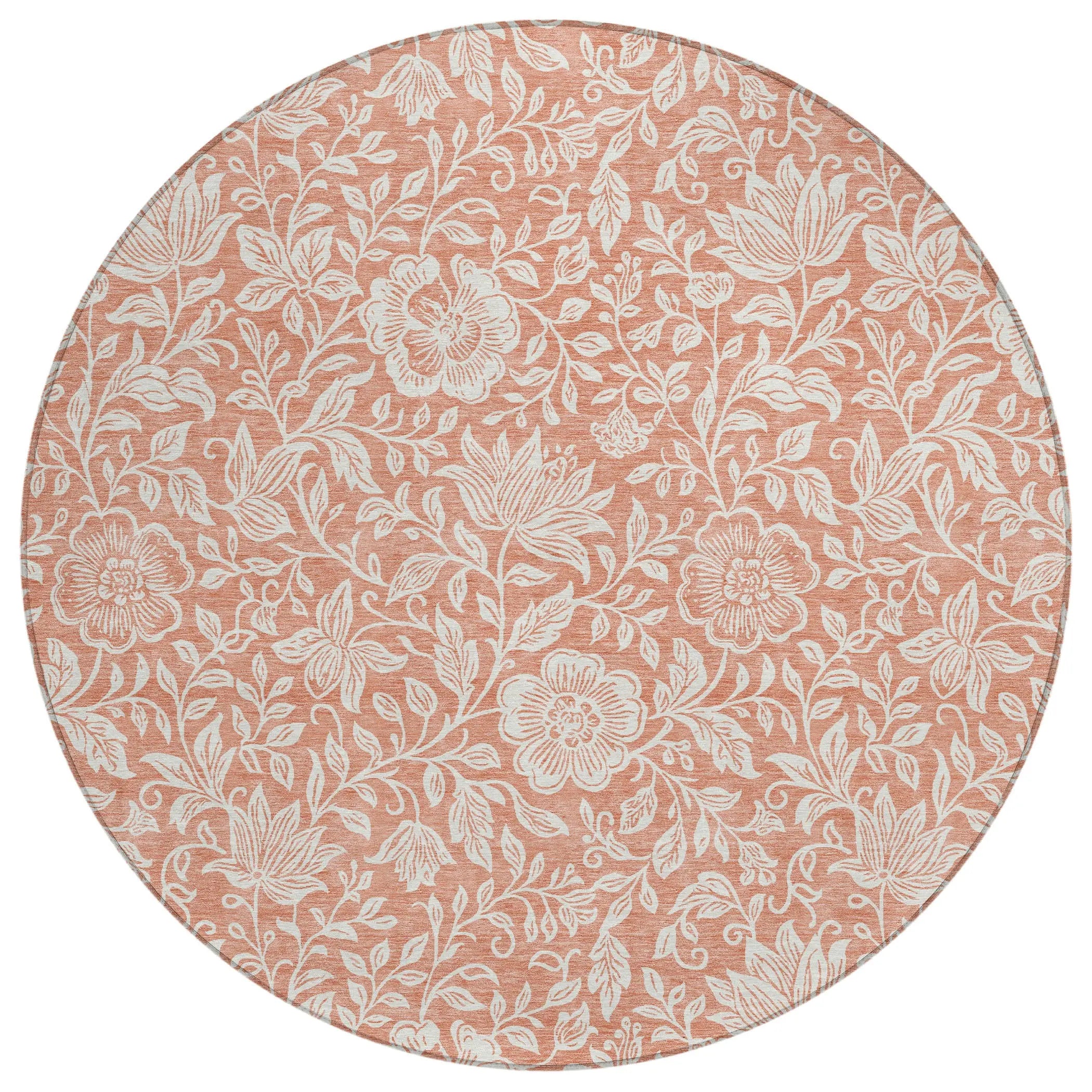 Round floral area rug in coral pink with white botanical patterns, perfect for adding a touch of elegance to any space.