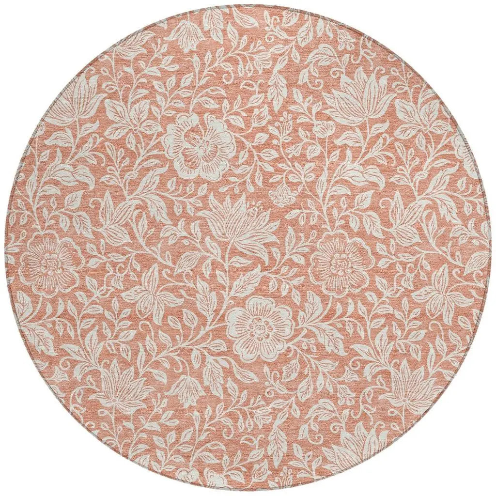 Round floral area rug in soft peach with white botanical designs, perfect for adding warmth to any room.