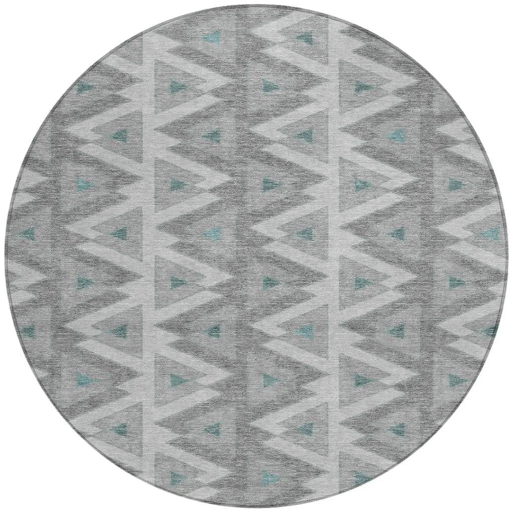 Round gray geometric area rug with teal accents, featuring a modern tribal pattern in soft, durable material.