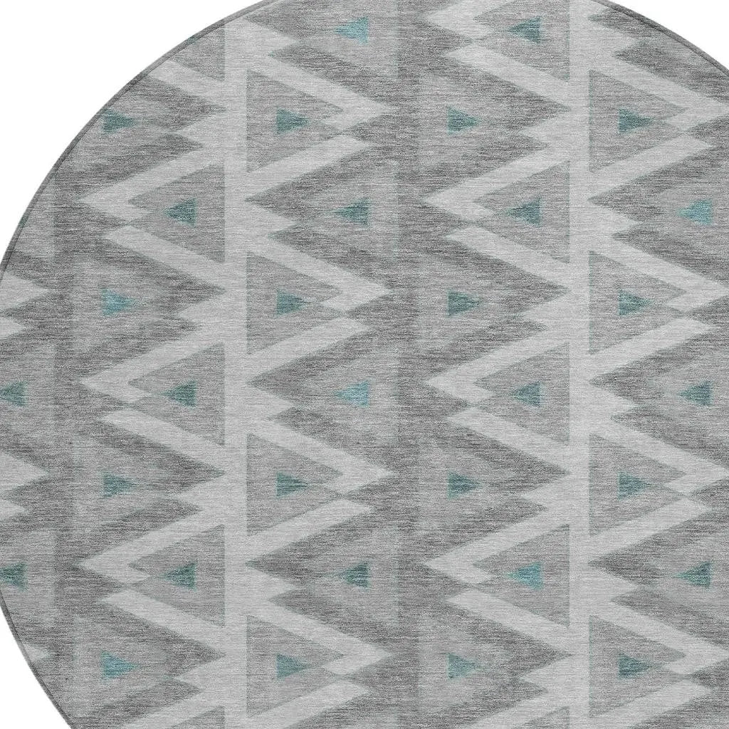 Round gray geometric area rug with teal accents and tribal pattern, perfect for modern decor.