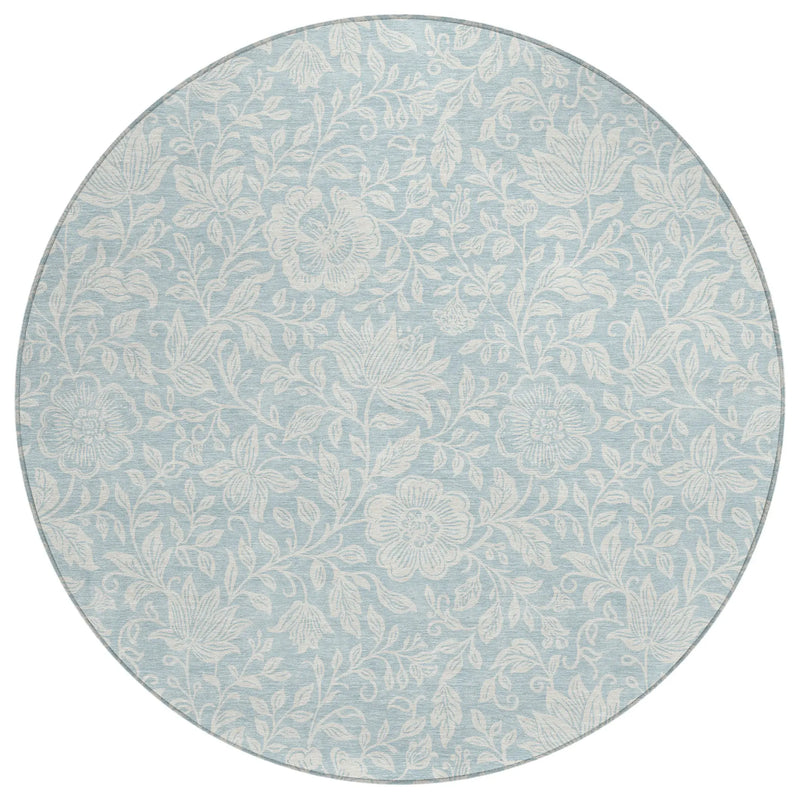 Round light blue floral area rug in soft materials, featuring intricate white botanical patterns for elegant decor.