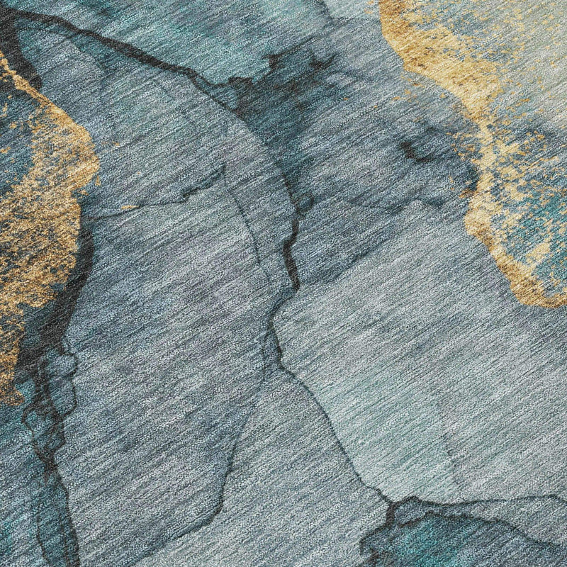 Abstract rug featuring teal, gray, and gold tones, made of soft, durable synthetic fibers for modern decor.