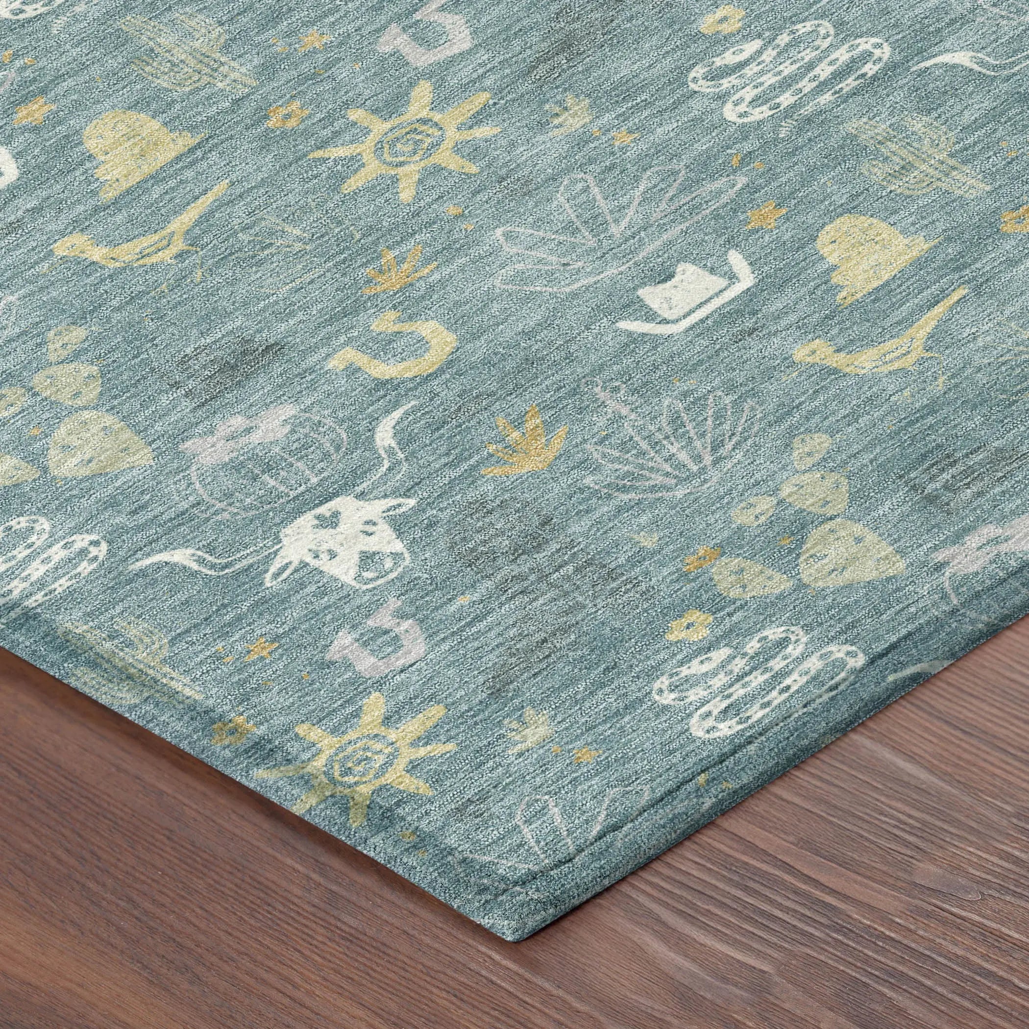 Aqua blue area rug with whimsical desert motifs in cream and gold, featuring cacti, birds, and stars, perfect for boho decor.