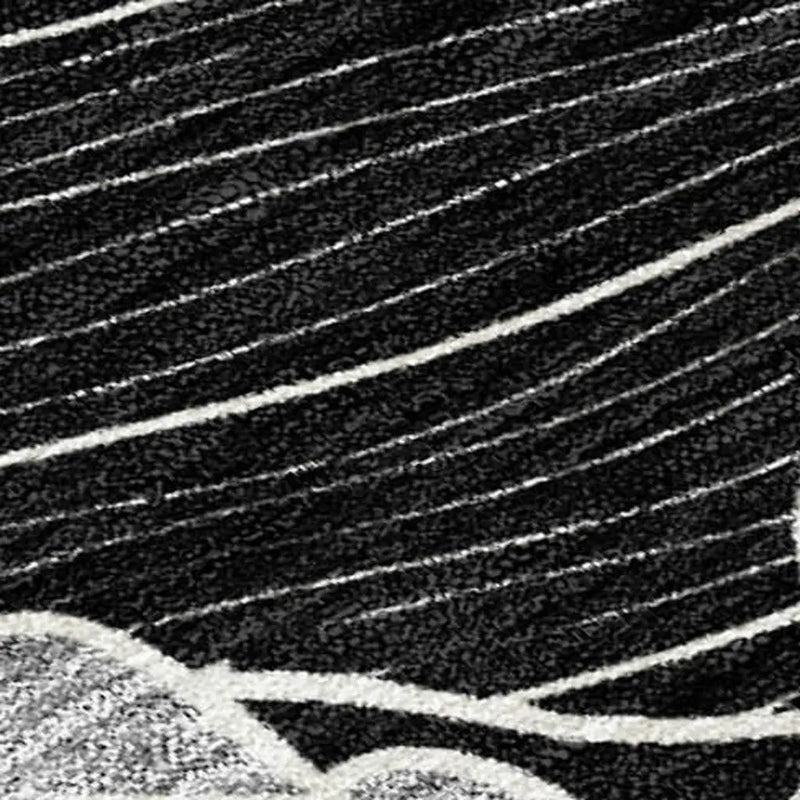 Black and white abstract area rug with textured lines and waves, crafted from durable synthetic fibers.