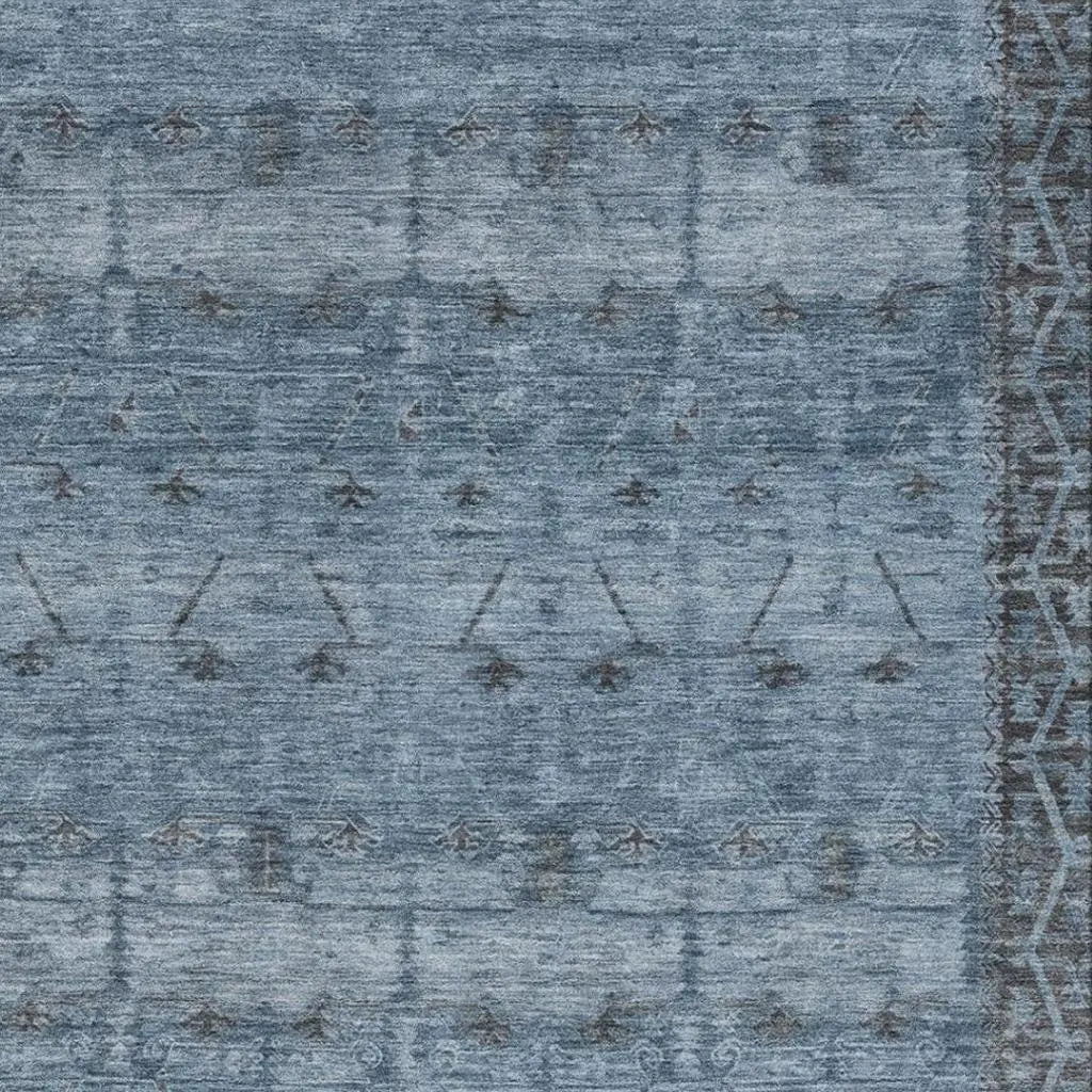 Blue geometric patterned area rug made of soft wool, featuring a vintage-style design with intricate detailing.