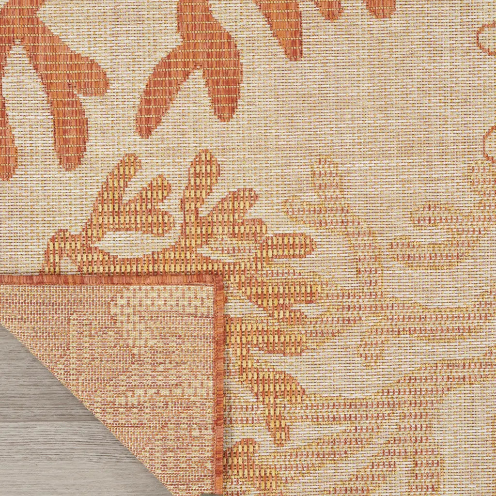Orange floral outdoor rug, woven texture, durable material, perfect for patios, 5x7 feet.