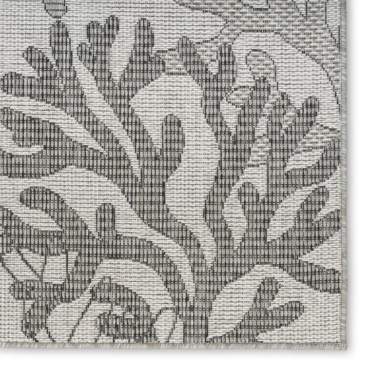 Gray woven area rug with an intricate coral and floral design, perfect for modern coastal decor.