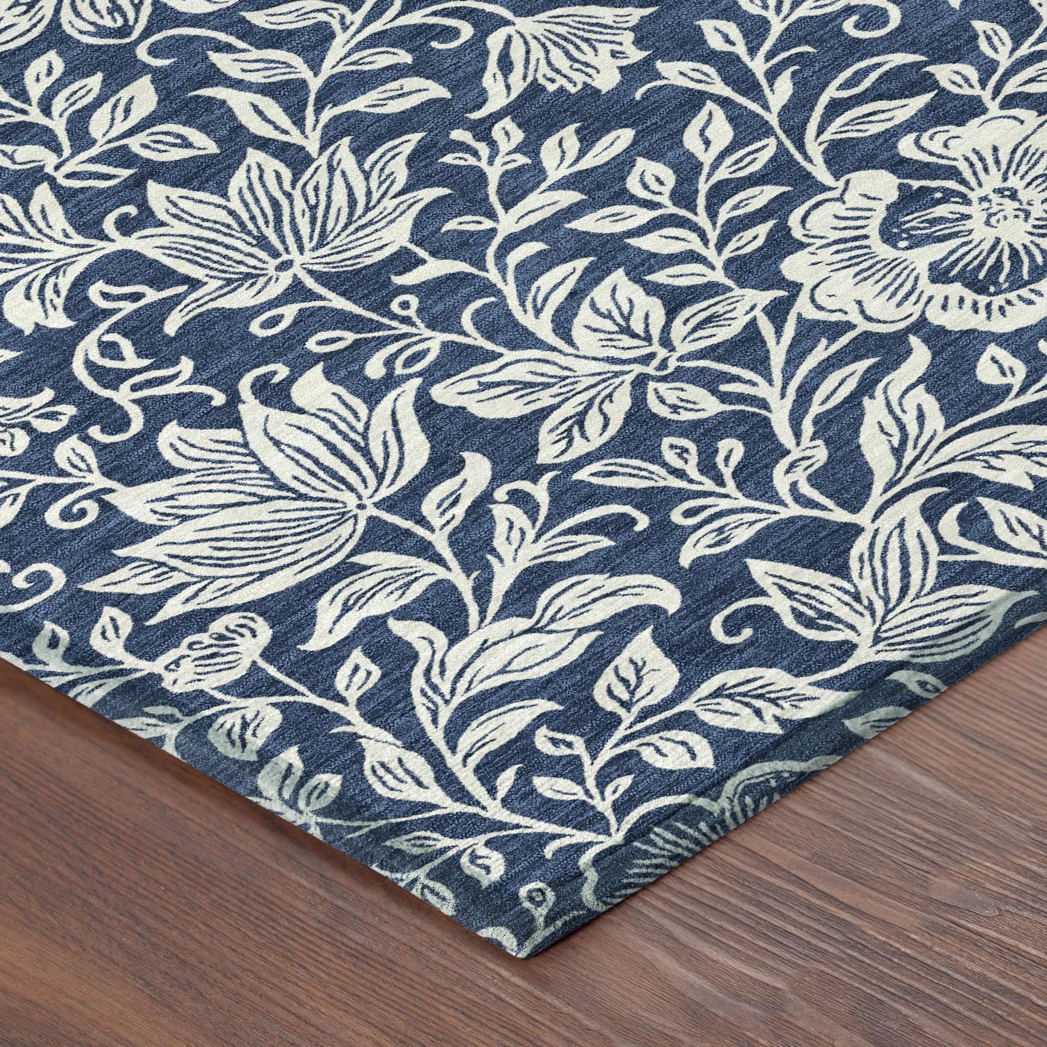 Navy blue floral area rug with ivory botanical design, soft textile, perfect for modern or eclectic decor.