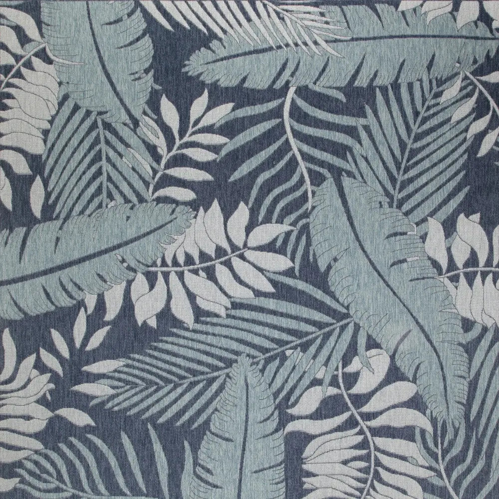 Blue and white tropical leaf patterned upholstery fabric, perfect for home decor.