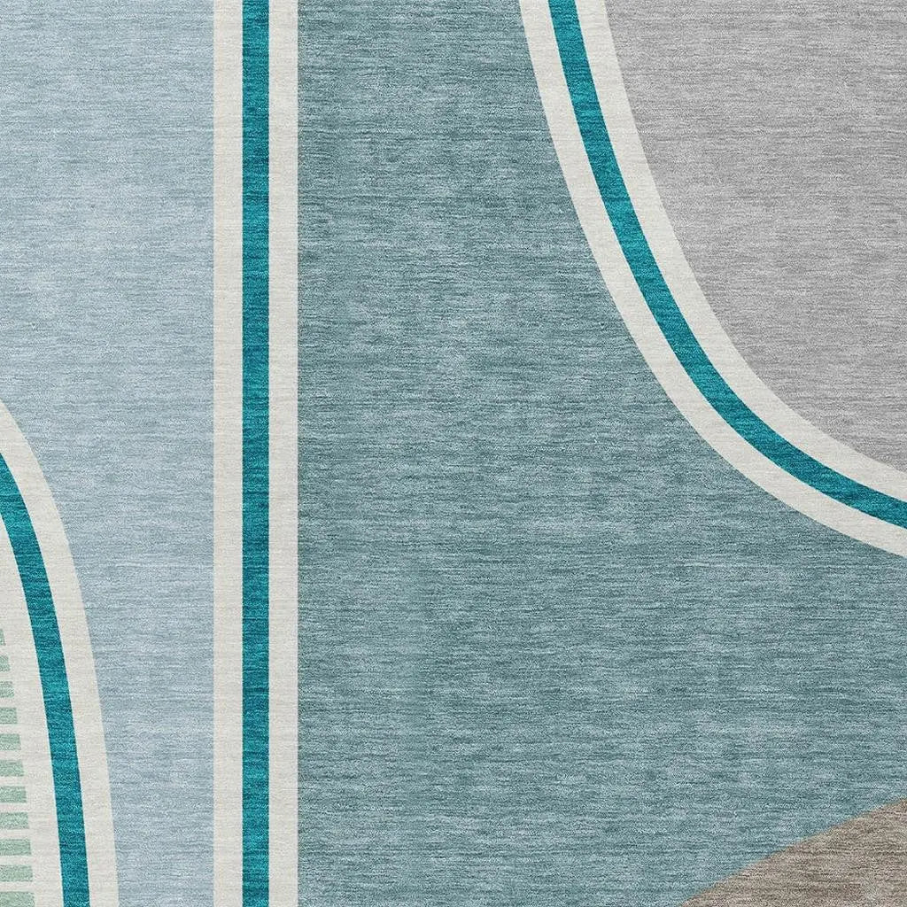 Abstract area rug in soft blue, grey, and teal color palette; modern design with geometric patterns and plush texture.