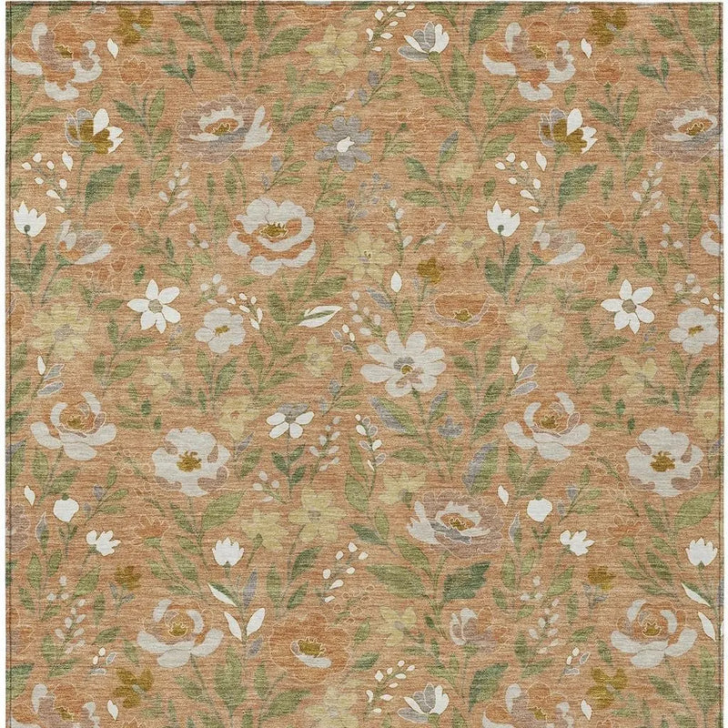 Floral area rug in warm orange with green and white blooms, featuring a soft, textured finish and vintage-inspired style.