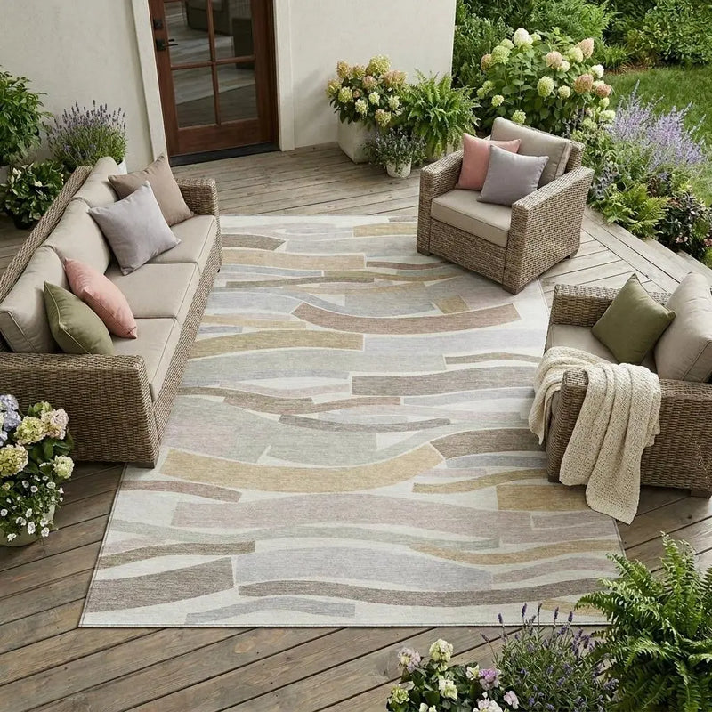 Beige and gray abstract outdoor rug, woven design, perfect for patio or deck, paired with wicker furniture and cushions.