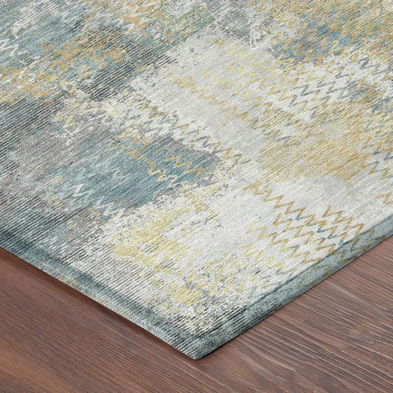Abstract teal and gold area rug with textured patterns on a soft gray background, ideal for modern decor.
