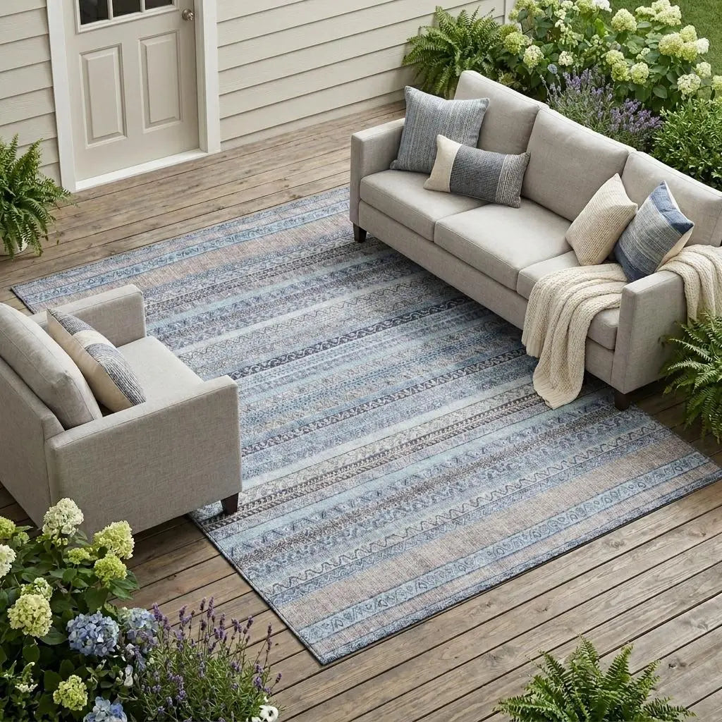 Coastal blue patterned area rug on wooden patio with light gray sofas and decorative pillows, perfect for outdoor decor.