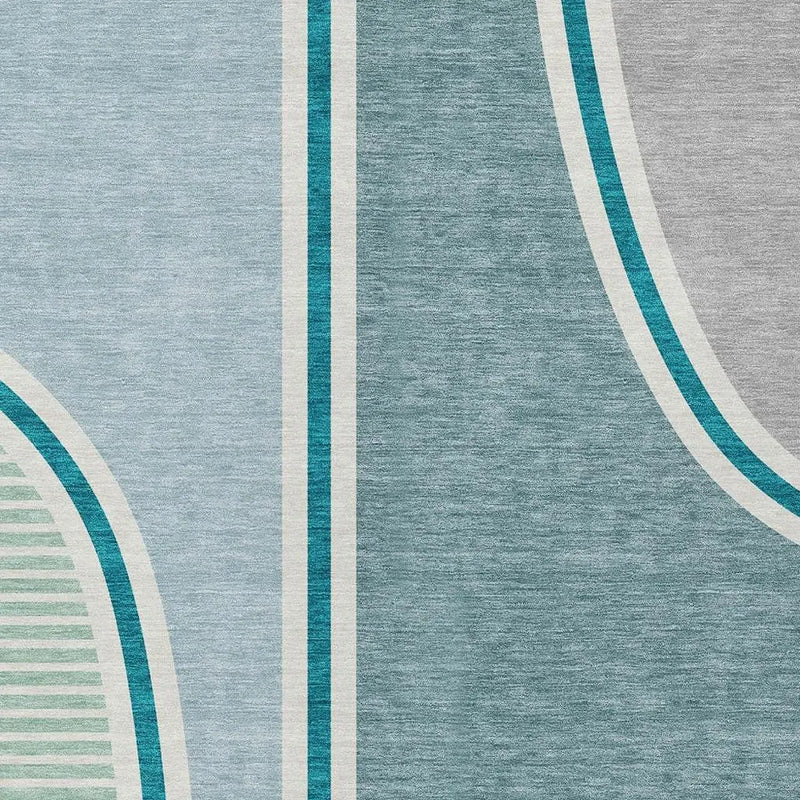 Modern area rug in teal, gray, and cream, featuring geometric patterns and soft, plush synthetic fibers.