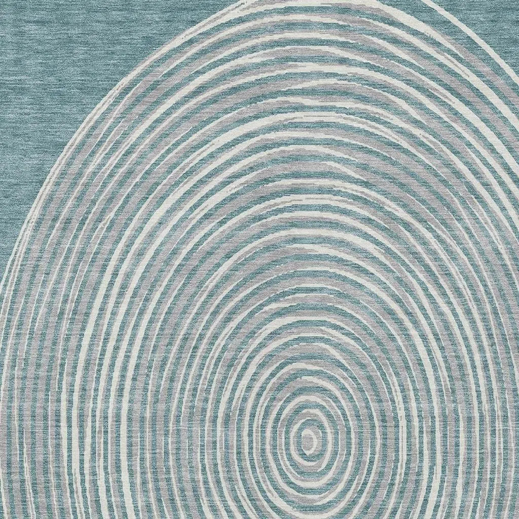 Blue and white abstract rug featuring circular wave patterns, crafted from soft, durable synthetic fibers.