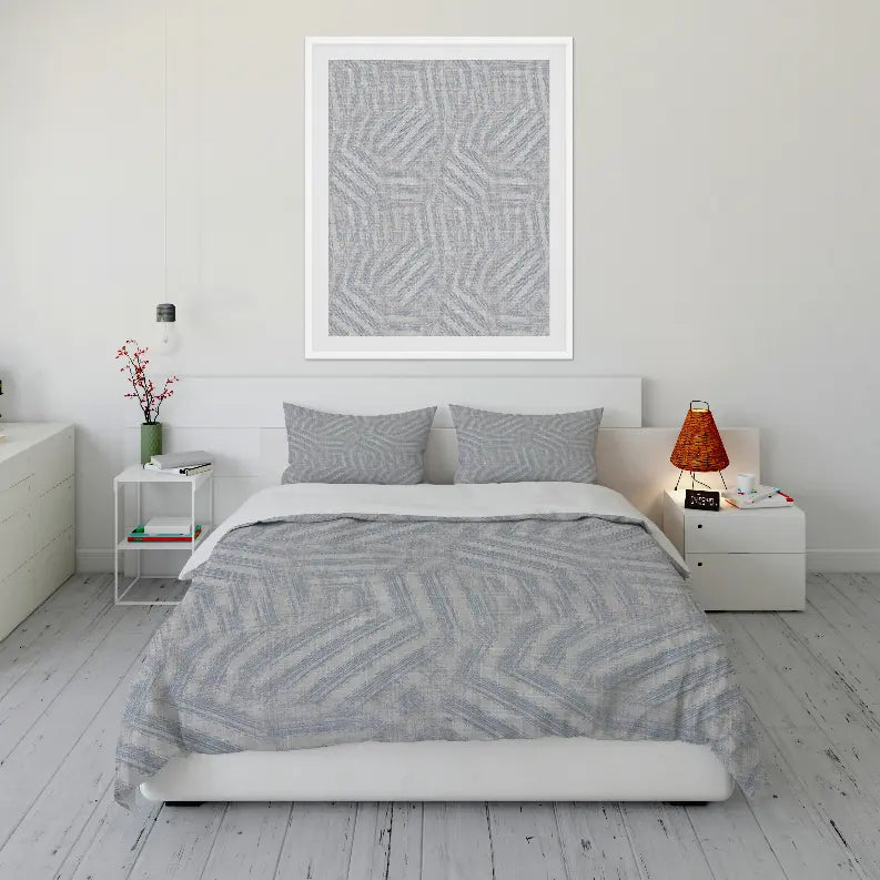 Light gray geometric patterned bedding set with matching pillowcases, styled in a modern bedroom.