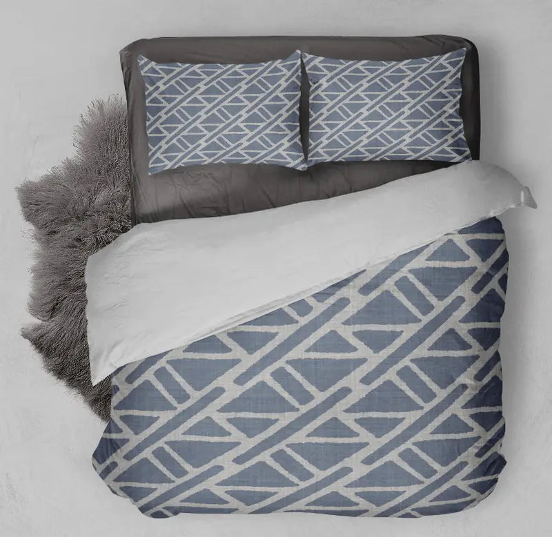 Navy blue geometric patterned bedding set with white accents, includes duvet cover and two pillow shams on a gray background.