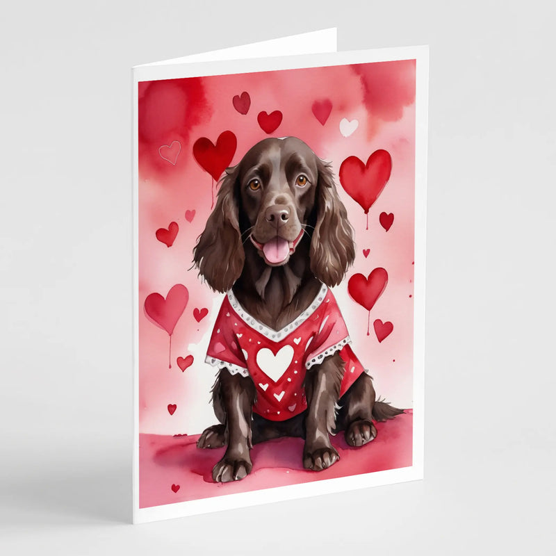 Brown dog in a red heart-patterned shirt, surrounded by pink and red hearts on a Valentine’s Day greeting card.