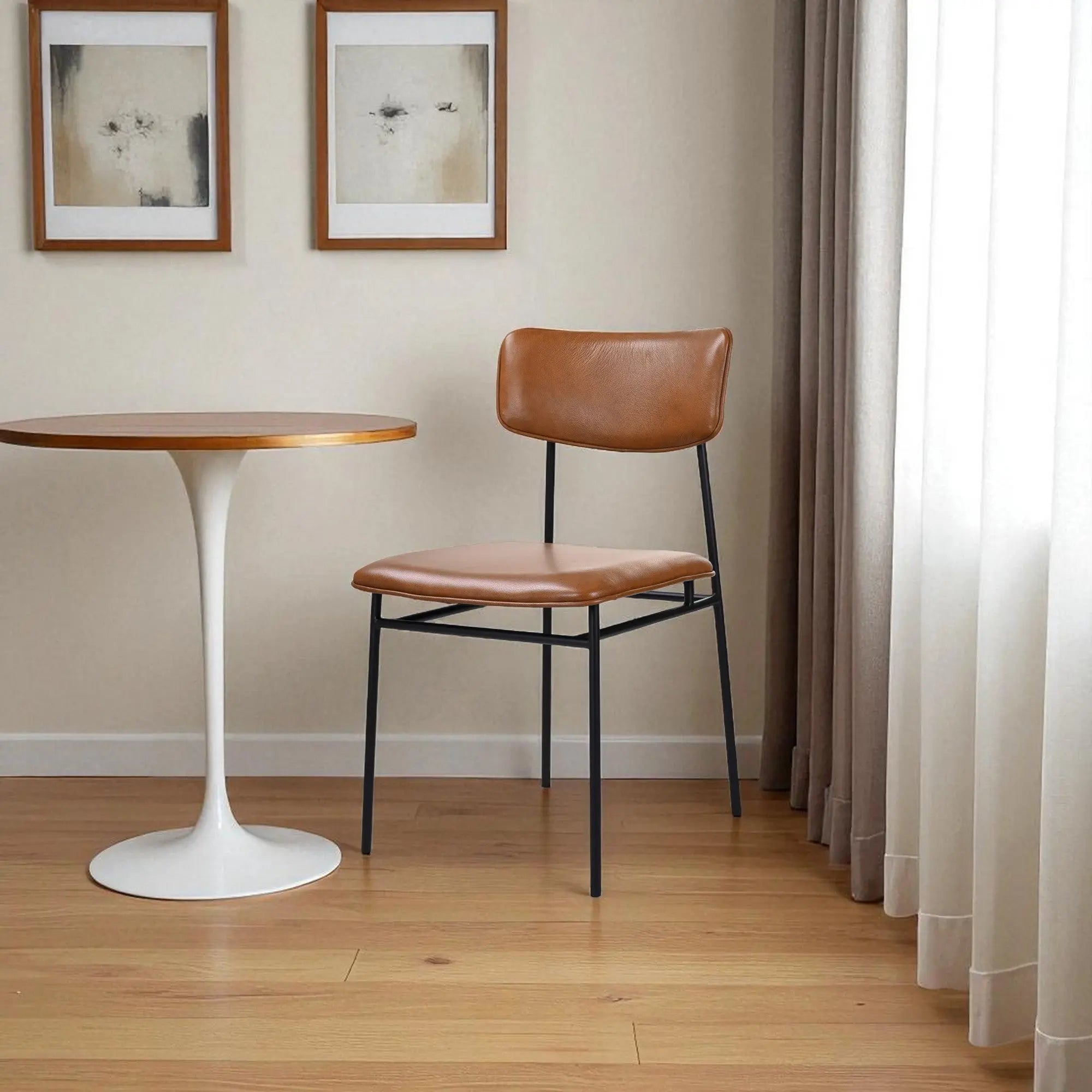 Mid-century modern chair with a brown leather seat and black metal frame, styled in a cozy, minimalist interior.