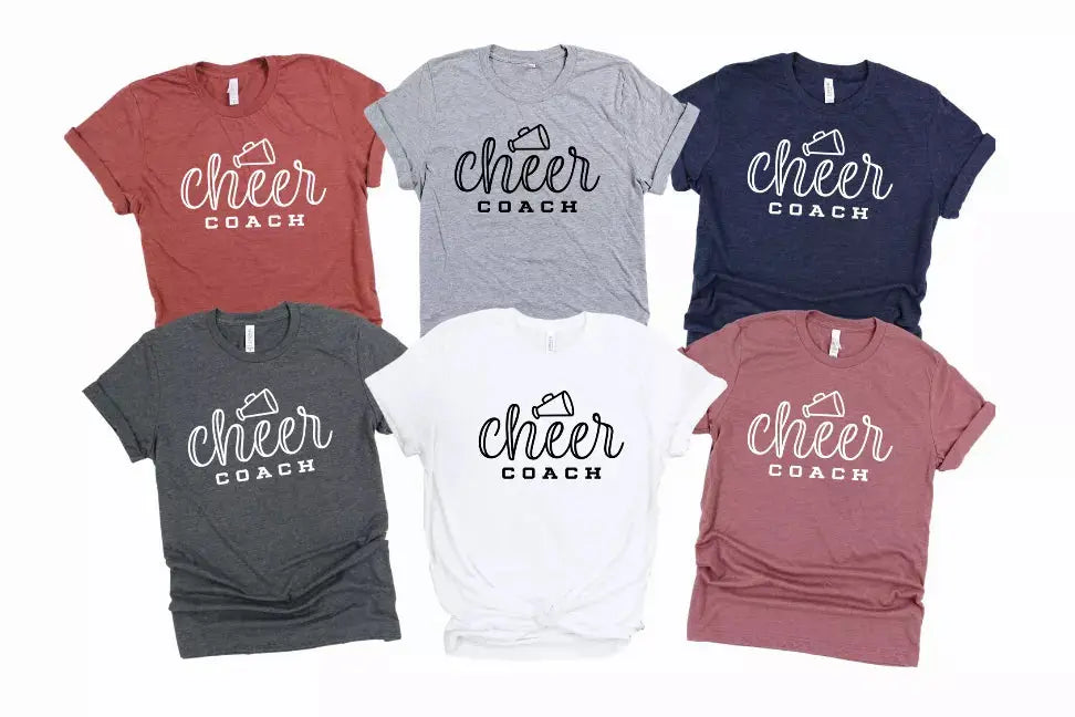 Collection of unisex cheer coach graphic tees in maroon, gray, navy, and white, made from soft cotton blend fabric.