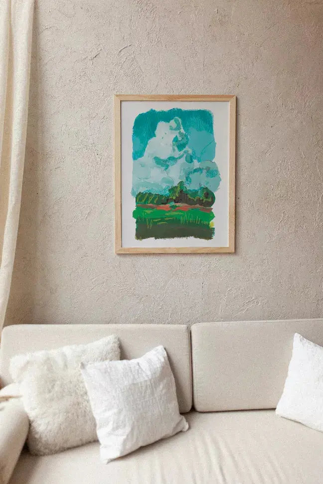 Framed abstract art print in teal and white, featuring a landscape, on a textured wall above a light sofa with pillows.