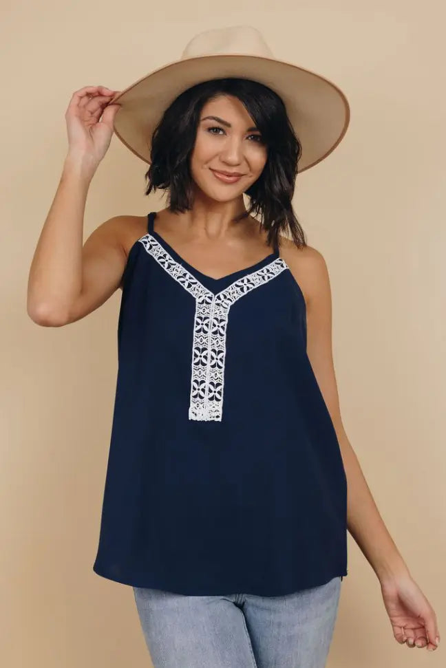 Navy blue sleeveless top with white embroidered detailing, perfect for casual summer outfits. Lightweight, stylish fabric.