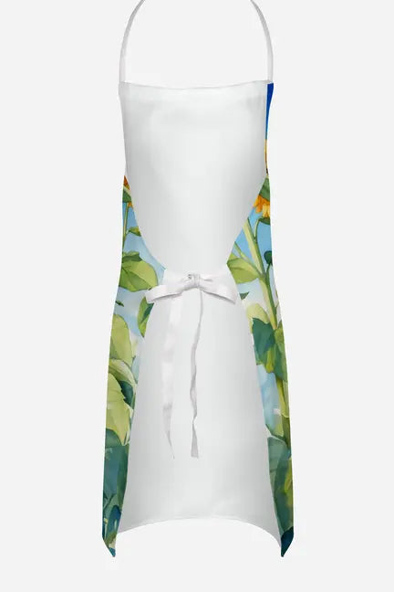 White canvas apron with vibrant floral print in green and yellow, featuring adjustable straps and a waist tie.
