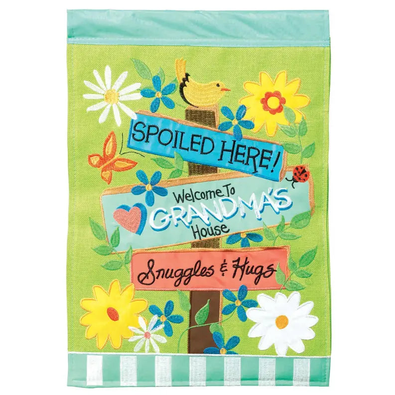 Colorful garden flag with a green background, featuring floral designs and signs reading "Grandma's House" and "Spoiled Here!"