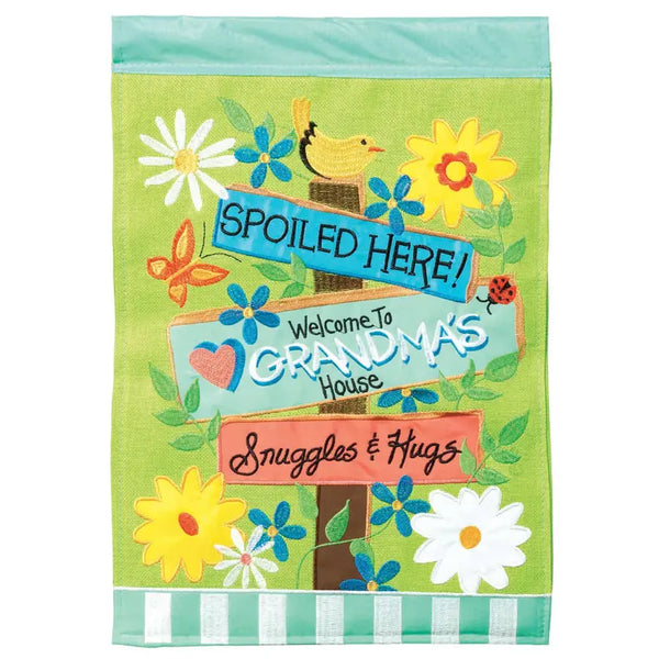 Colorful garden flag with a green background, featuring floral designs and signs reading "Grandma's House" and "Spoiled Here!"