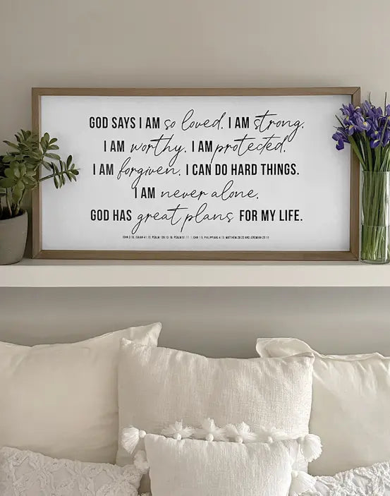 Framed wall art with motivational quotes in black typography on a white background, accented by a natural wood frame.