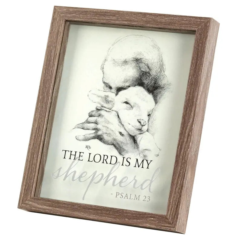 Framed art print featuring a shepherd and lamb illustration, gray and white colors with a rustic wood frame.